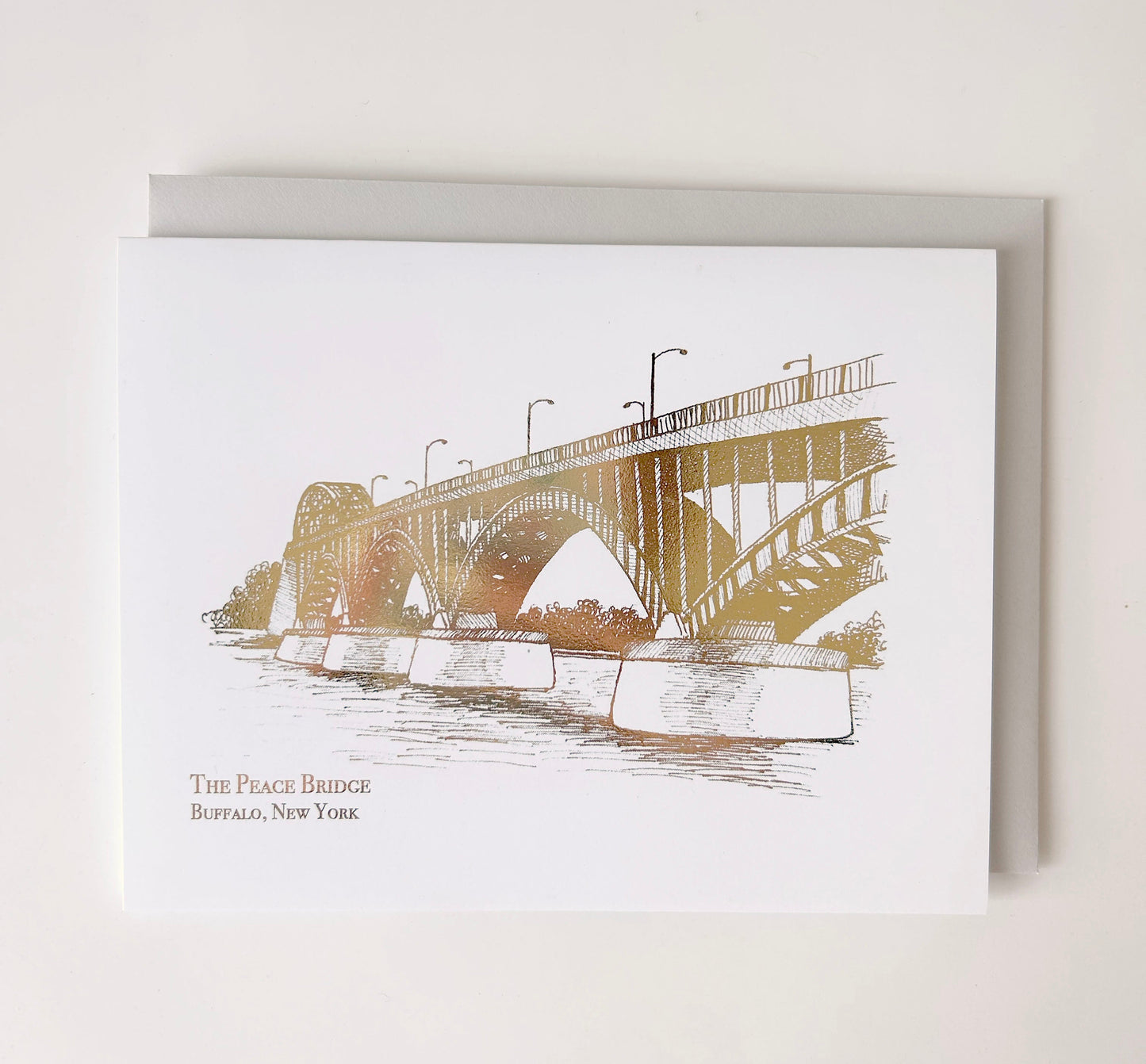 Gold foil illustration that says "The Peace Bridge Buffalo, New York" designed by Rust Belt Love