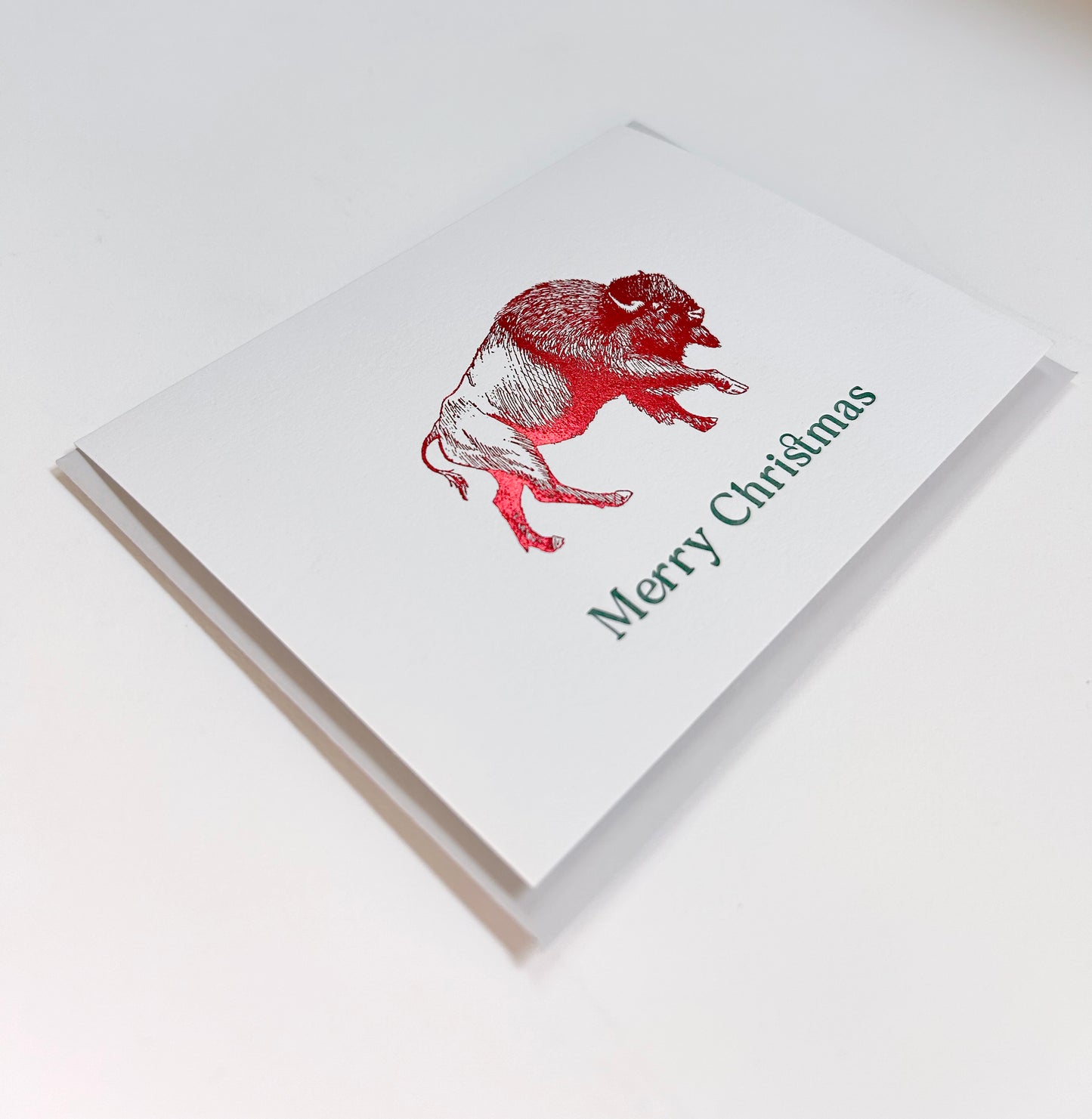 Red foil buffalo greeting card by Rust Belt Love that reads "Merry Christmas"