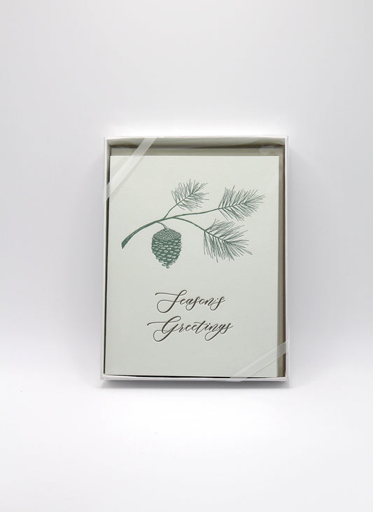 Box of letterpress holiday cards with pinecone that says "Season's greetings" by Rust Belt Love