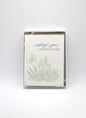 Box of letterpress holiday cards with snowdrop flowers that says "Wishing You A Snowy Solstice" by Rust Belt Love