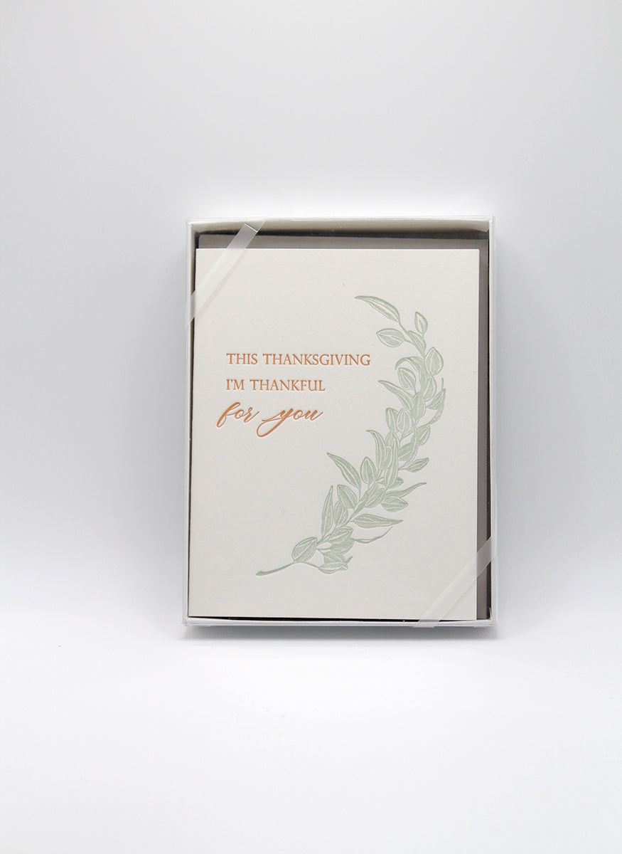 Box of letterpress thanksgiving cards with greenery that says "This Thanksgiving I'm Thankful For You" by Rust Belt Love