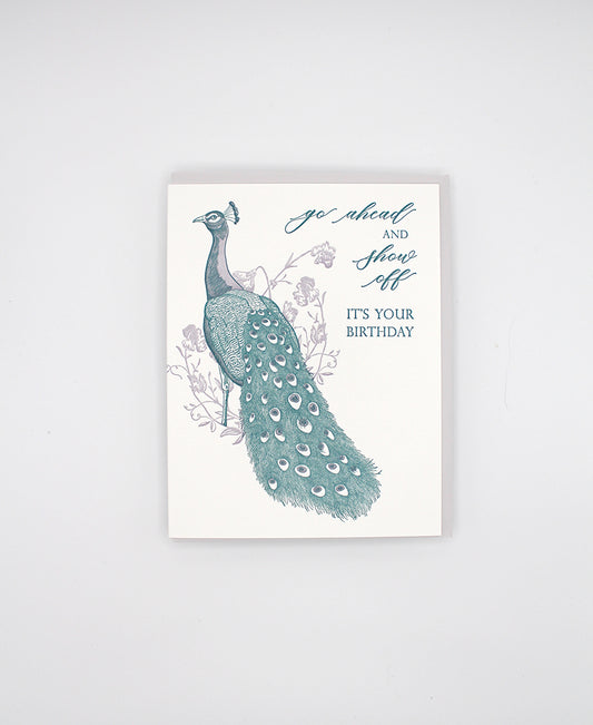 Letterpress birthday greeting card with purple and teal ink, with florals and a peacock that reads "Go ahead and show off it's your birthday", by Rust Belt Love.