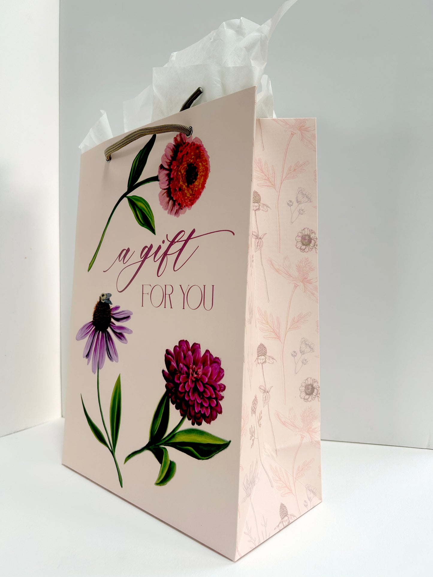 Angled  picture of pink birthday gift bag with florals that reads " A Gift For You" by Rust Belt Love
