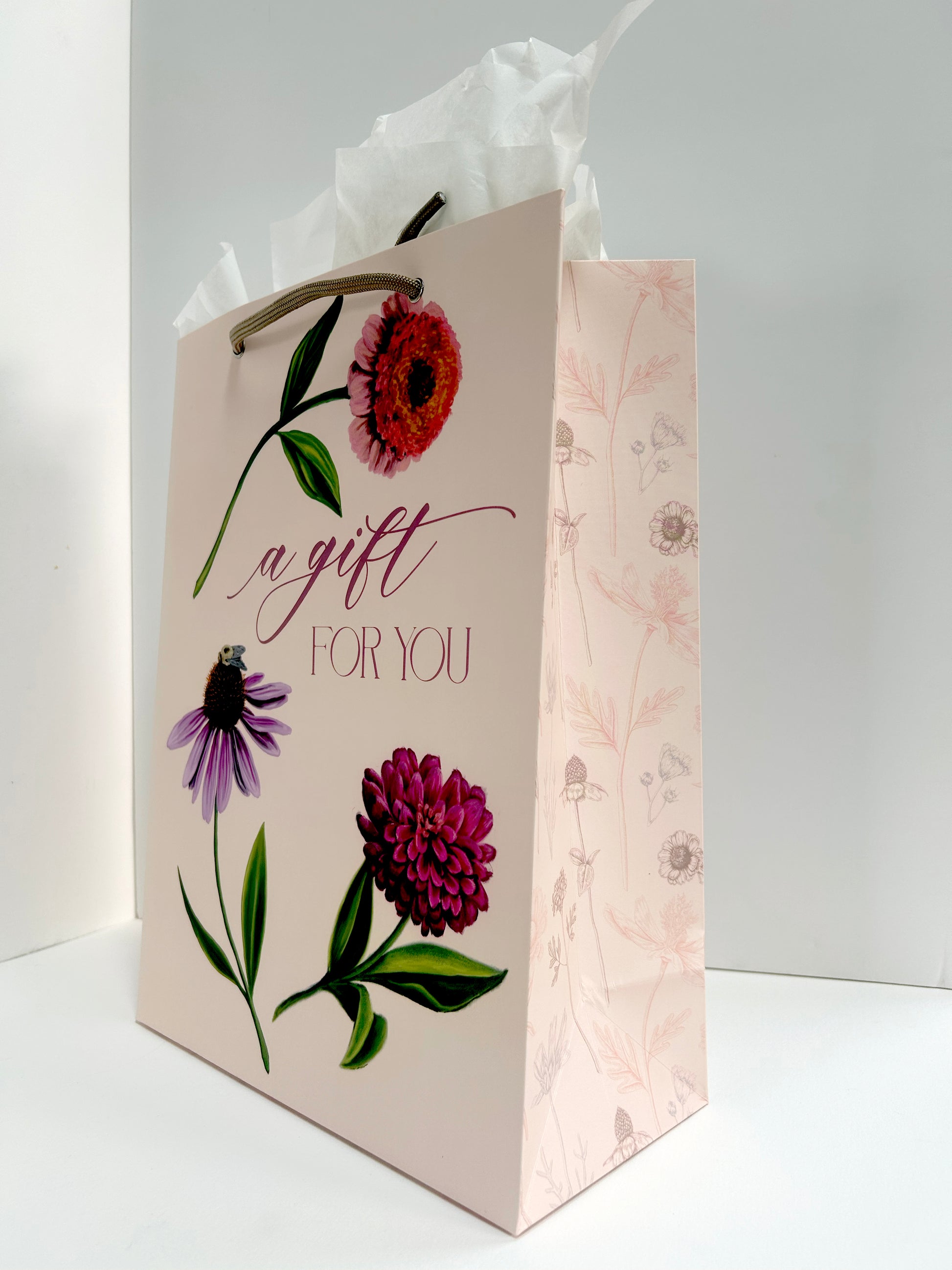 Angled  picture of pink birthday gift bag with florals that reads " A Gift For You" by Rust Belt Love