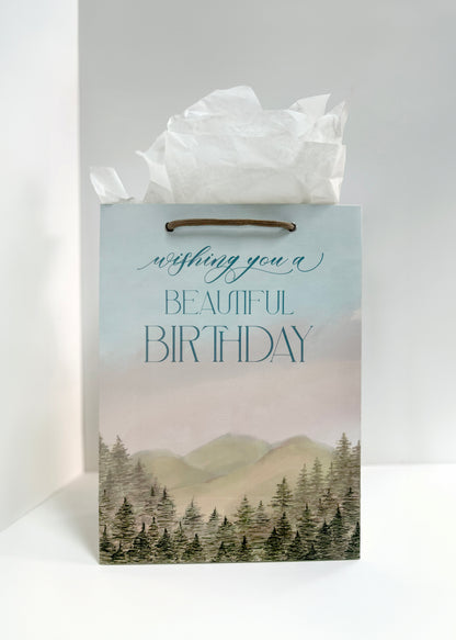 Rust Belt Love's birthday gift bag with mountain and tree scenery that reads "Wishing you a beautiful birthday"