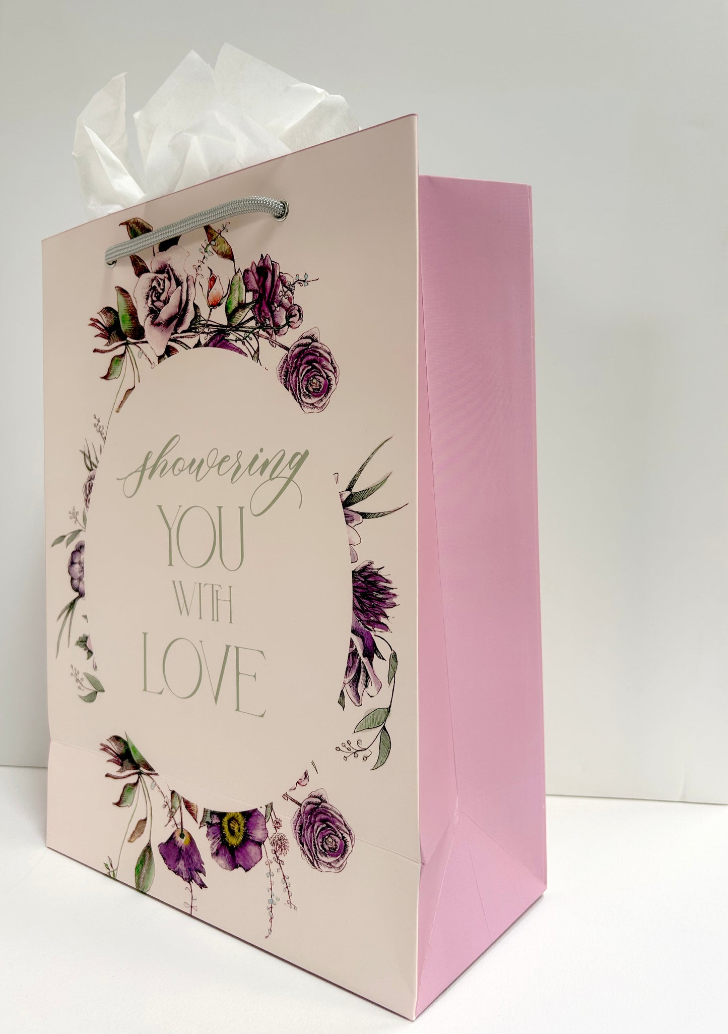 Angled standing pink bag with florals that reads "Showering you with love" from Rust Belt Love