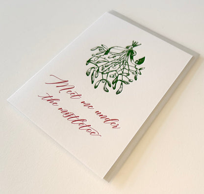 Letterpress holiday card with mistletoe that says "Meet me under the mistletoe" by Rust Belt Love