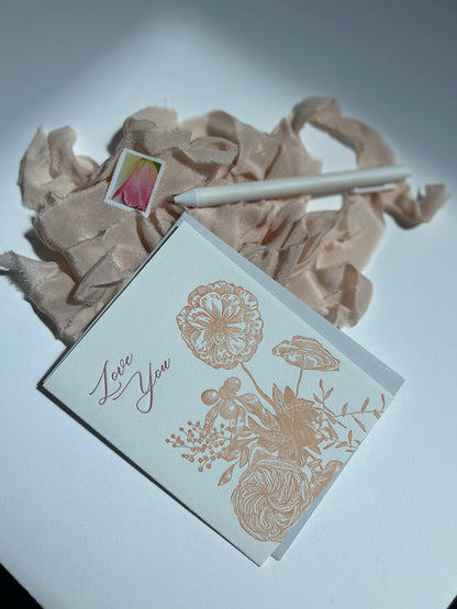 Style shot of letterpress love card with florals that says "Love you" by Rust Belt Love