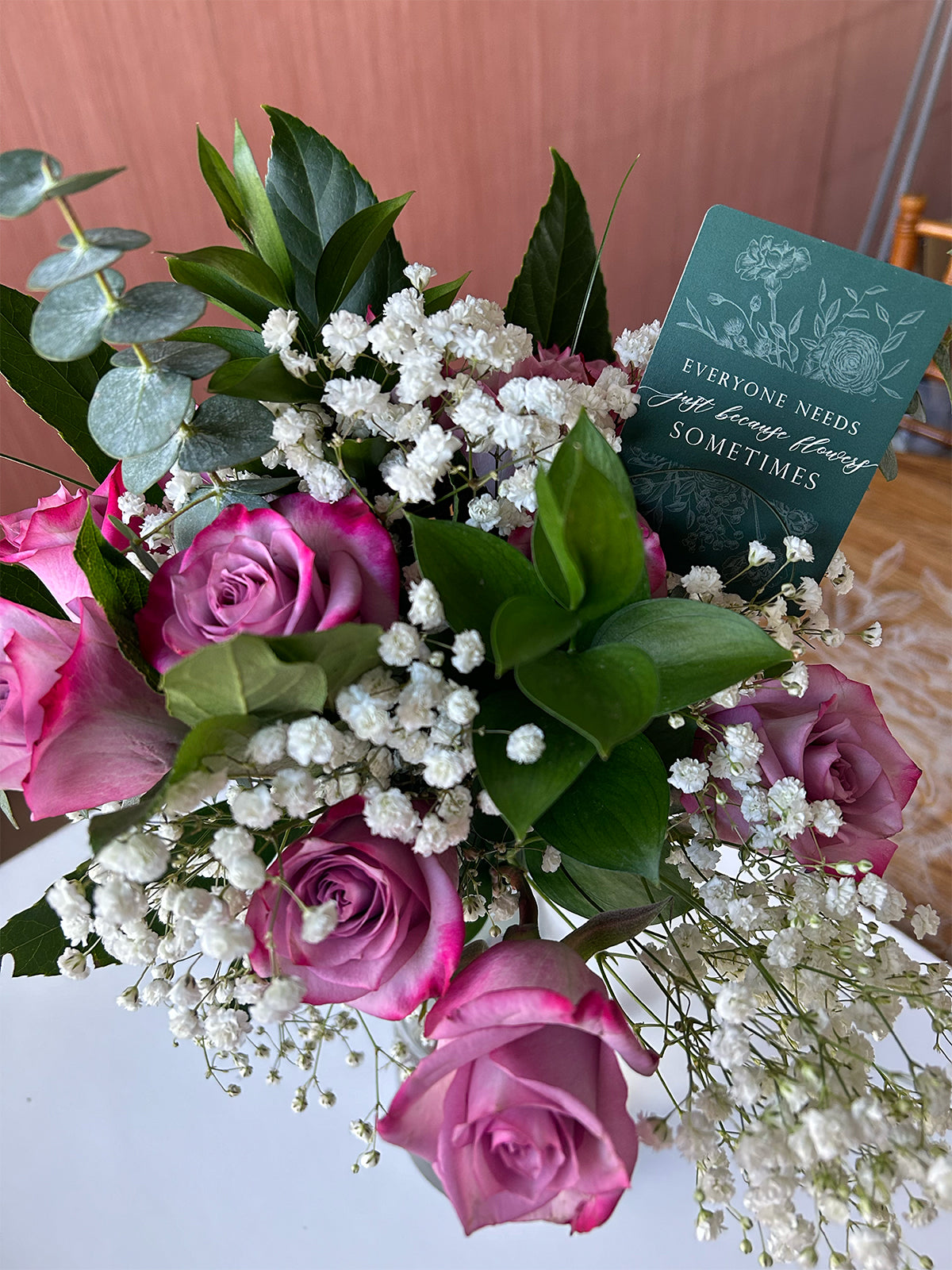 Style shot of minicard in a bouquet of flowers that reads "Everyone needs just because flowers sometimes" by Rust Belt Love