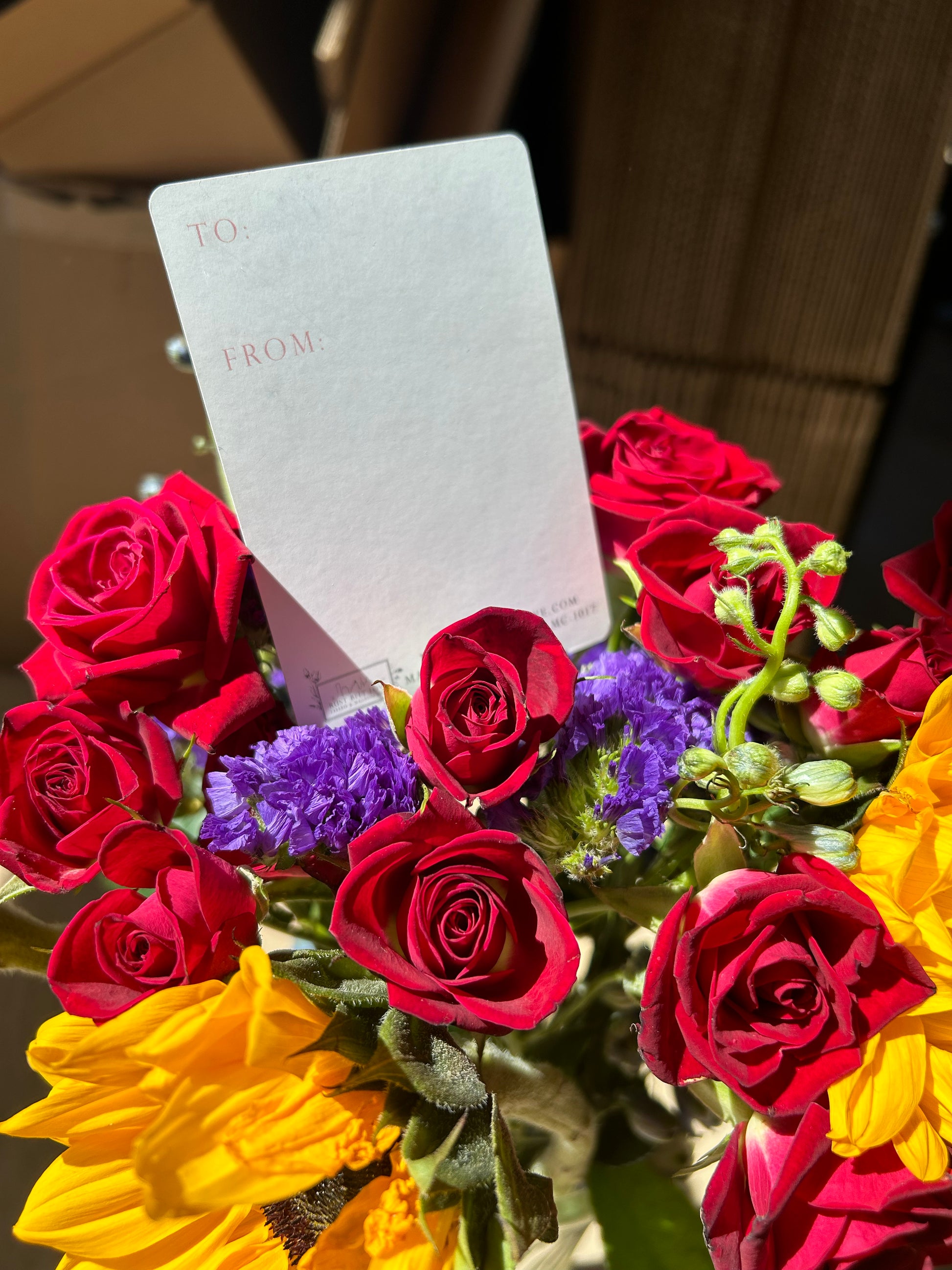 A style shot of the back of a minicard in a bouquet of flowers 