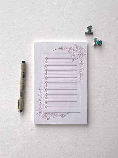 Style shot of 5.5 by 8.5 notepad with lined sheets with dusty rose florals  by Rust Belt Love