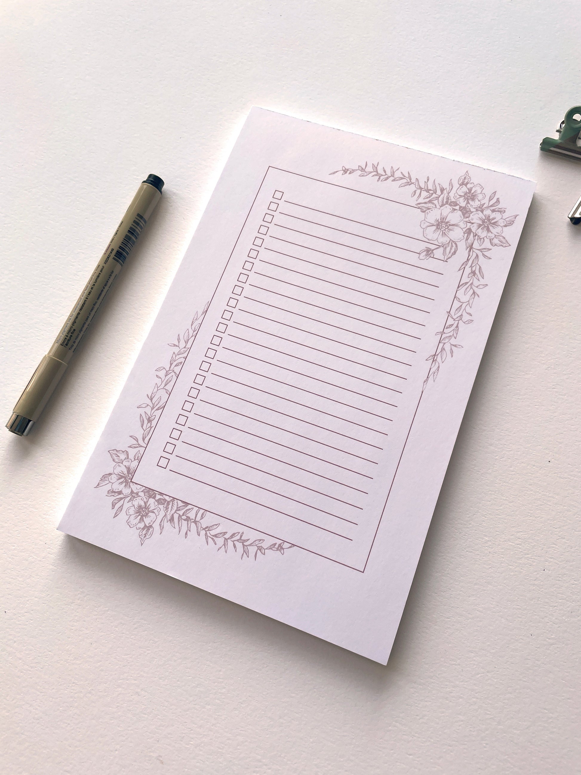 Style shot of 5.5 by 8.5 notepad with lined sheets with dusty rose florals  by Rust Belt Love