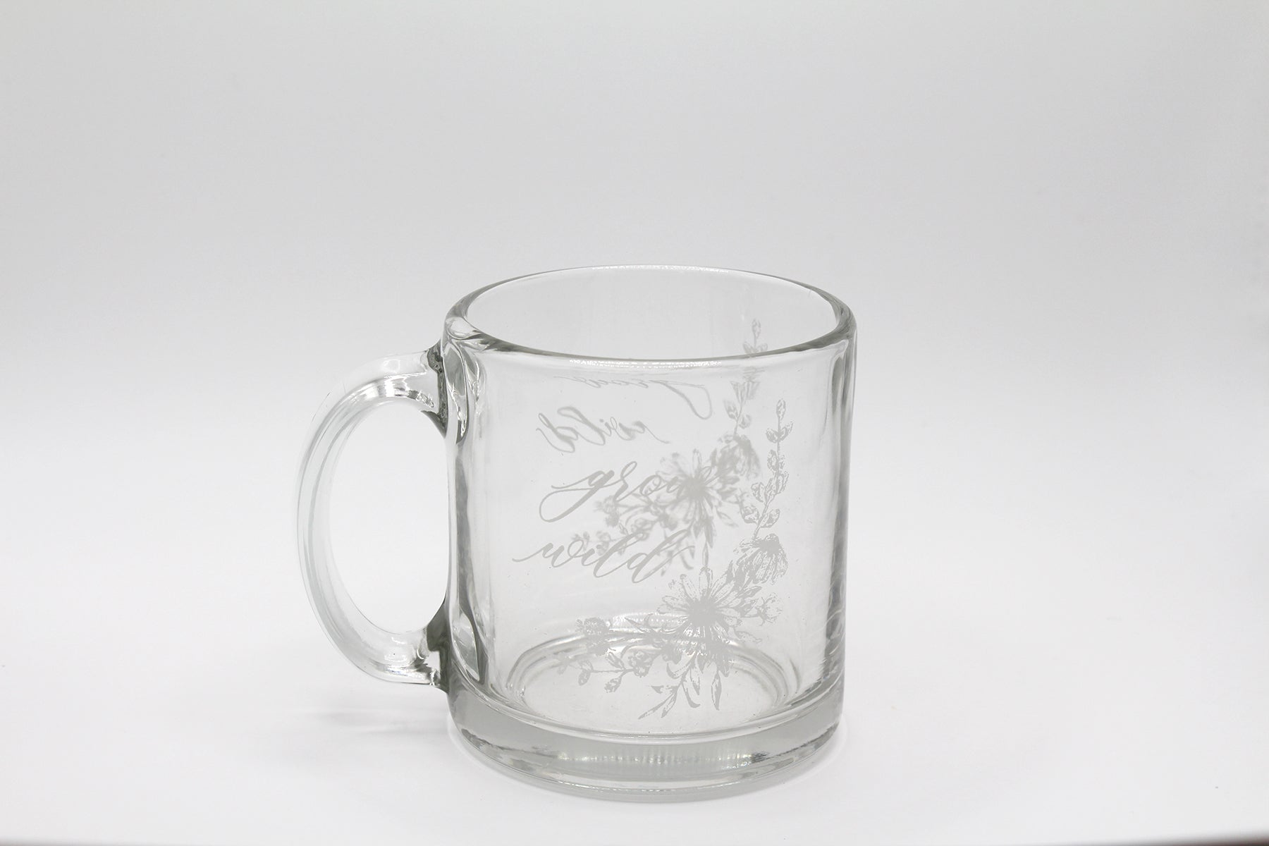 White ink on clear glass mug with flowers and that says "grow wild" by Rust Belt Love