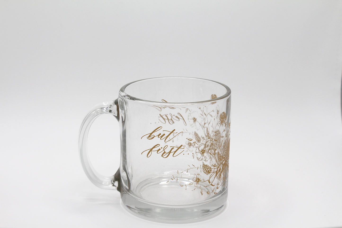 Gold ink on clear glass mug with florals and that says "but first..." by Rust Belt Love