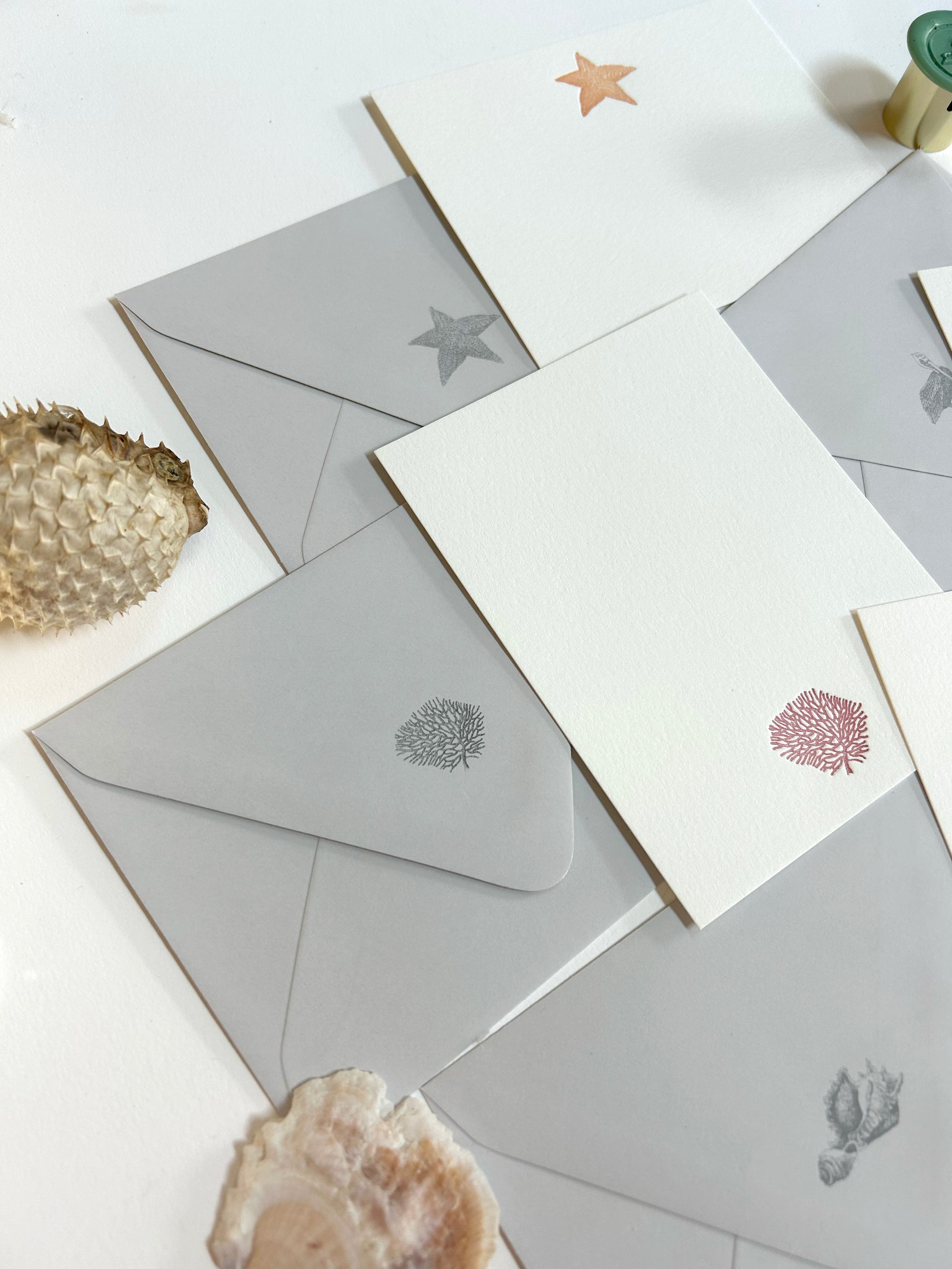 Style shot of letterpress note cards with various seaside designs with matching grey envelopes. Flat cards designed by Rust Belt Love