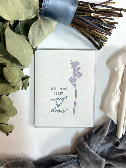 A style shot of Rust Belt Love's letterpress floral wedding card that reads "Will you be my maid of honor"